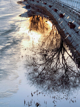 Winter river scene with tree reflections and icy water