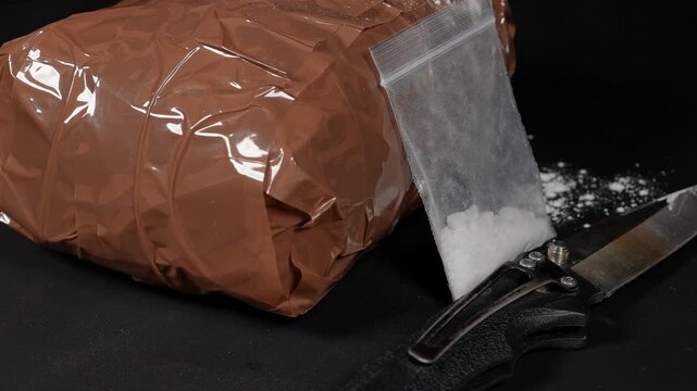Concept of brown packages filled with drugs and wrapped in duct tape to avoid k9 dog detection by smell at the border. Educational concept of drugs in powder for pill pressing for distribution. 