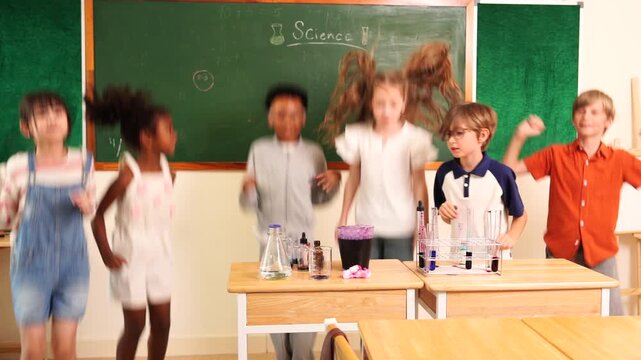 group of boys and girls, of multinational nationality jumping excited in front of their classmates learning science, mixing chemicals, holding test tubes in their classroom at school