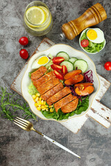 Healthy Grilled Chicken Salad with Fresh Vegetables and Boiled Egg on Rustic Wooden Board © PhanThi