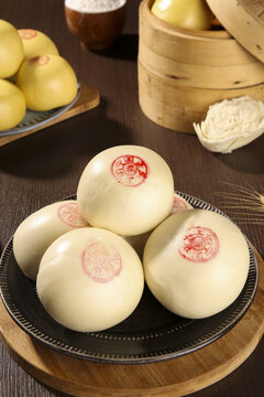 Traditional Chinese Steamed Buns with Red Stamps on Wooden Plate - Authentic Asian Cuisine