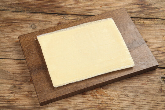 Fresh Tofu Skin Sheet on Wooden Board Ready for Healthy Asian Cooking and Noodle Preparation
