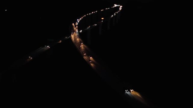 Night aerial view of Rodovia dos Imigrantes highway with vehicle traffic and lights connecting Santos and S&atilde;o Paulo, Brazil. Push in camera movement