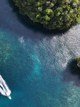Aerial View of a White Speed Boat Near Lush Tropical Islands