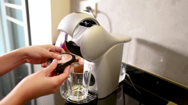 Person Inserting Coffee Pod into Modern Capsule Espresso Machine