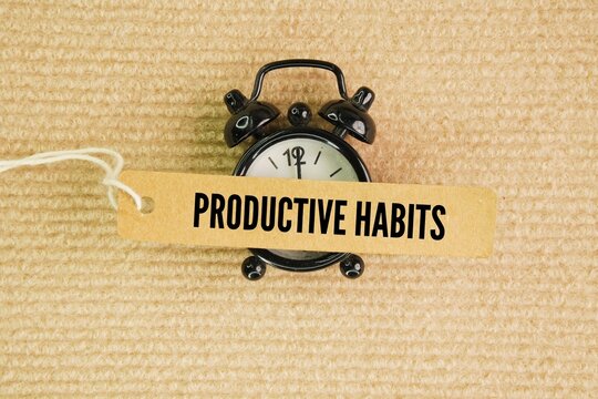 Alarm clock and paper tag with the word productive habits. daily routines that optimize your time, focus, and energy without leading to burnout. Instead of just working longer