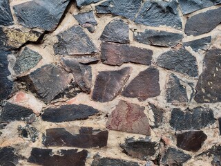 Fototapeta premium Irregular natural stone wall creating rough textured masonry pattern background