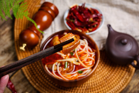 Spicy noodle soup with braised pork and chopsticks