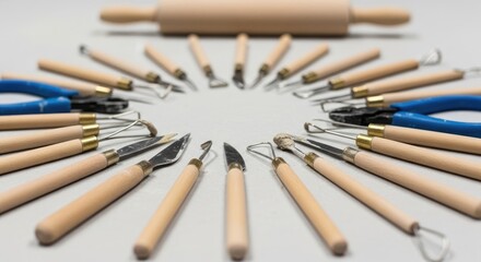 Fototapeta premium Artistic Pottery Tools Arranged in a Circular Pattern on White Surface.