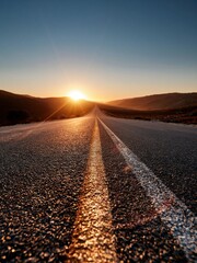 Fototapeta premium Open Highway Leading Towards a Brilliant Sunrise Over Rolling Hills
