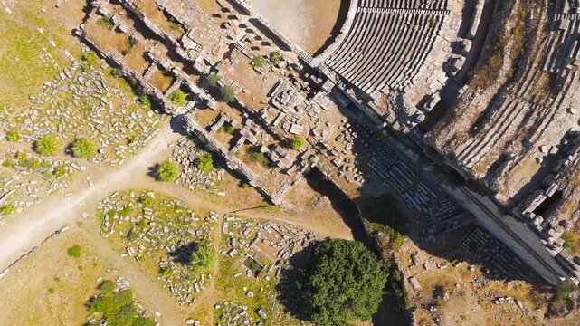 Balat, Turkey. The ancient Theatre of Miletus, its semi-circular cavea and stage building revealed in a slow top-down aerial rotation under bright summer sun. Aerial View, HEAD OVER SHOT with rotatio