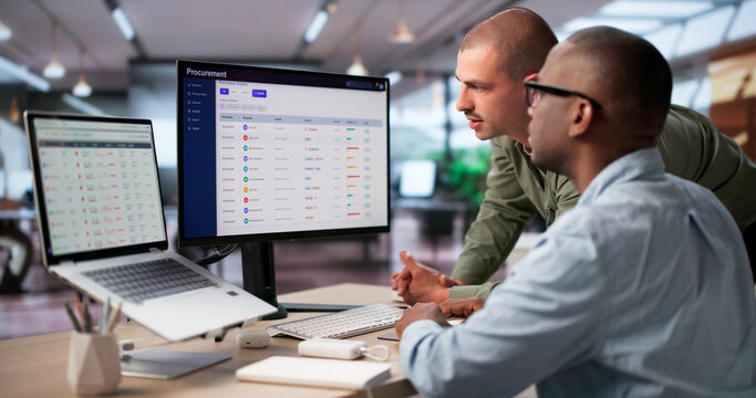 Procurement Manager And Colleague Discuss Software Platform