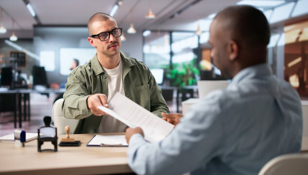 Young Man In Office Stamping Important Property Document