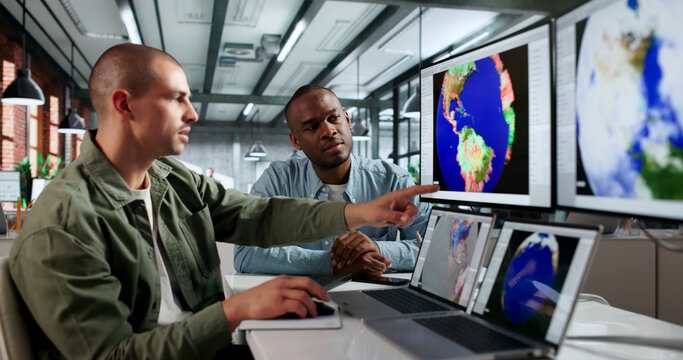 Two Meteorologists Analyze Climate Data On Computers