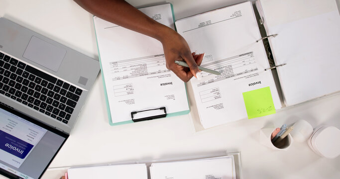 Accountant Reviews Invoices And Budgets While Advising Clients