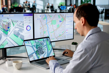 Fototapeta premium Engineer Studies Urban Property Maps On Laptop Using BIM