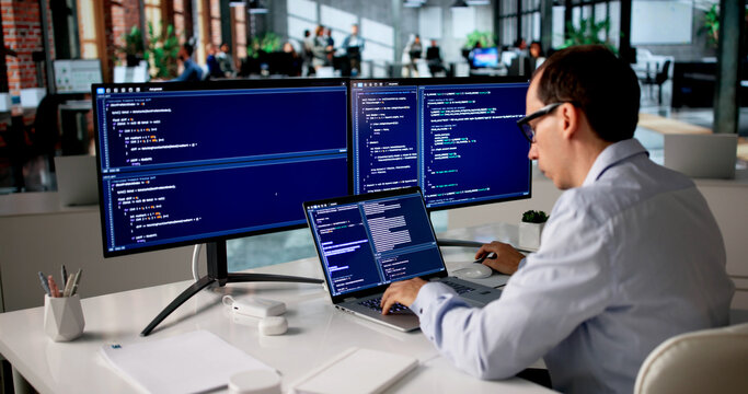 Man Sitting At Desk Typing Code