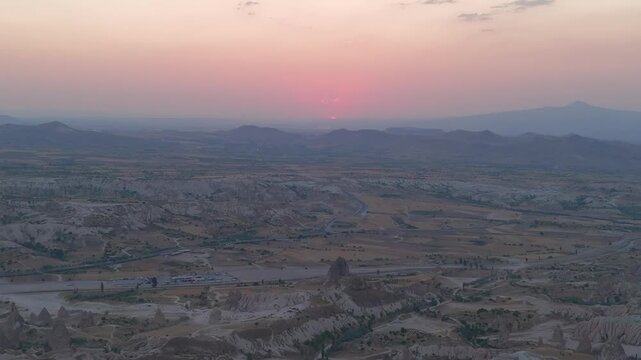 Goreme, Nevsehir, Turkey. Red Valley and Kizilcukur, panoramic drone view over eroded volcanic tuff formations at twilight with a fading pink afterglow. Aerial View
