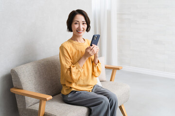 Obraz premium スマートフォンを操作する女性 ライフスタイルイメージ