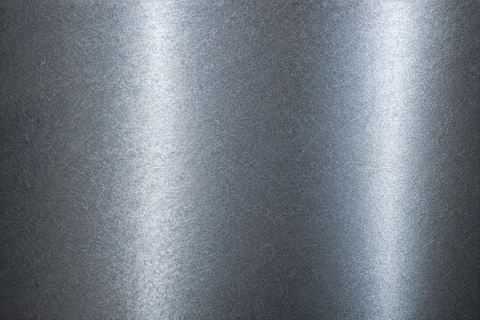Realistic brushed metal texture with polished stainless steel finish. Industrial silver metallic background featuring fine hairline scratches, smooth reflections, and premium steel surface details.
