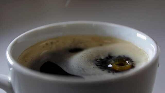 Milk drop to coffee cup and splashing up. Slow motion beverage background