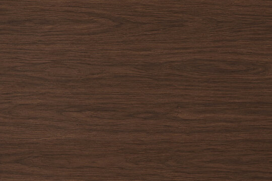 Dark walnut wood texture with deep brown tones, rich flowing grain, and smooth elegant surface. Ideal for furniture visuals, backgrounds, and luxury interior design.