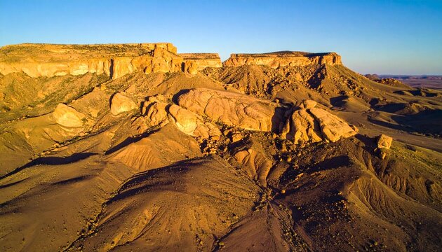 Aerial view of rocky desert plateau with rugged terrain and barren landscape