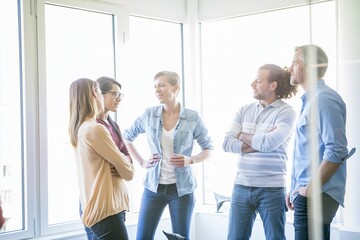 Fototapeta premium Creative business team talking together in office workspace