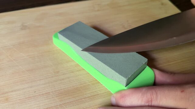 Kitchen knife sharpening on stone board close up