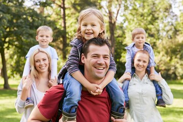 Fototapeta premium Cheerful parents and children spending day in park