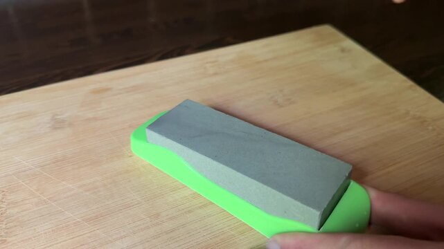 Kitchen knife sharpening on stone board close up
