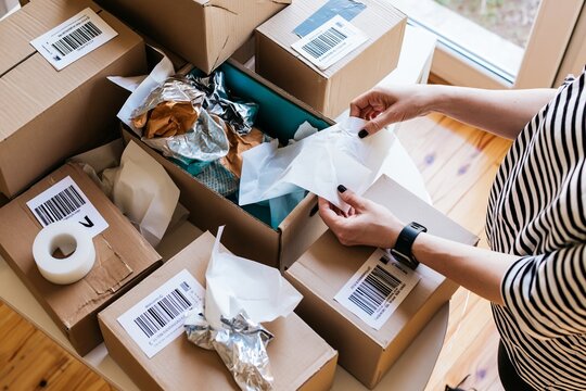 Organized ecommerce packaging station with labeled boxes and wrapping