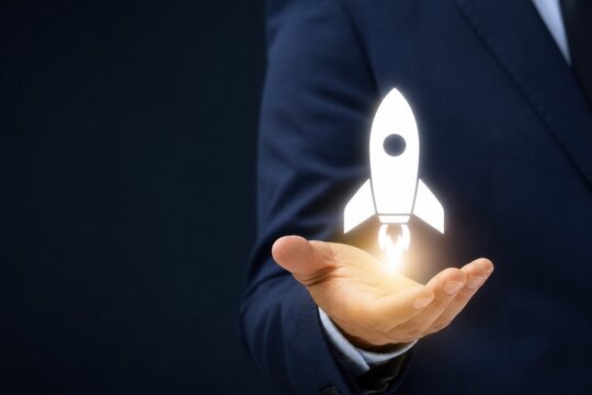 Entrepreneur's hand holds a launching rocket icon, symbolizing new business startup and innovative growth