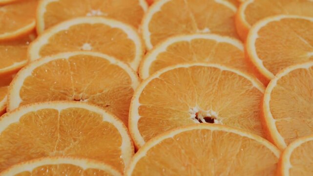 Vibrant orange fruit slices background with slow camera movement over fresh citrus texture for health concepts.