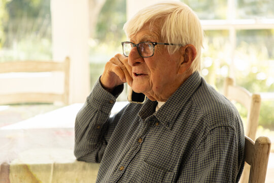 elderly man talking on cellphone at home