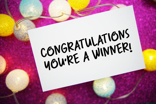 Congratulations You're a Winner! text written on paper card with LED cotton balls decoration