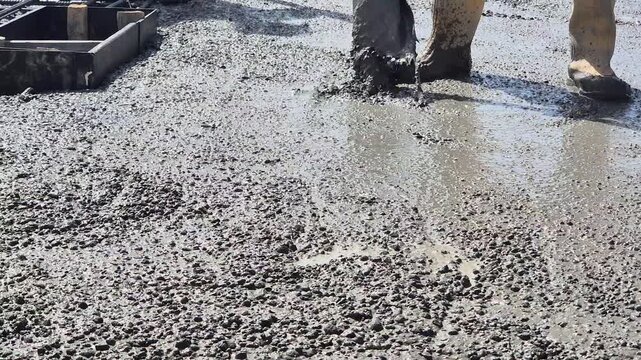 Vibrating freshly poured concrete slab low angle view