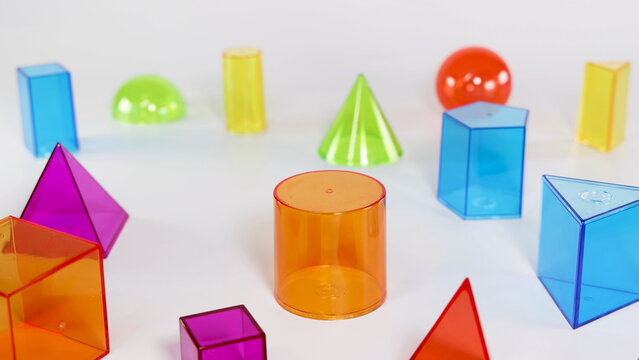 Colorful Translucent Geometric Solids Arranged on a White Surface