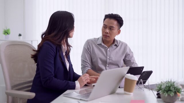young Asian business professionals discuss project strategy laptop meeting office consultation teamwork collaboration explain ideas present proposal modern