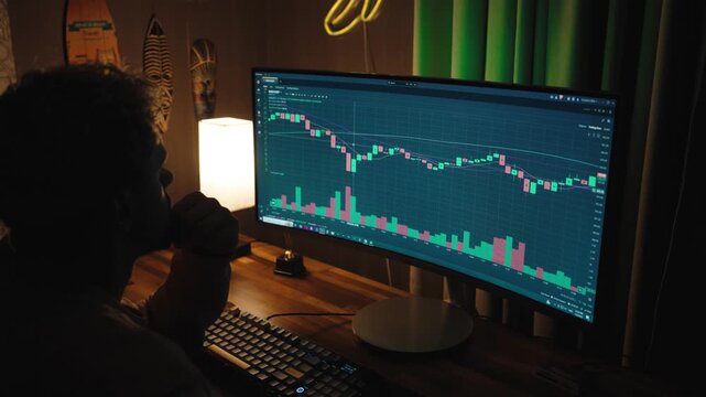 Professional trader or investor working at multiple monitors with stock market charts, financial data, and trading graphs.