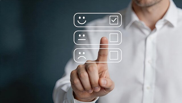 Businessman selecting positive smiley face on digital interface for customer satisfaction survey, feedback and rating concept with happy expression icon selected by finger touch.