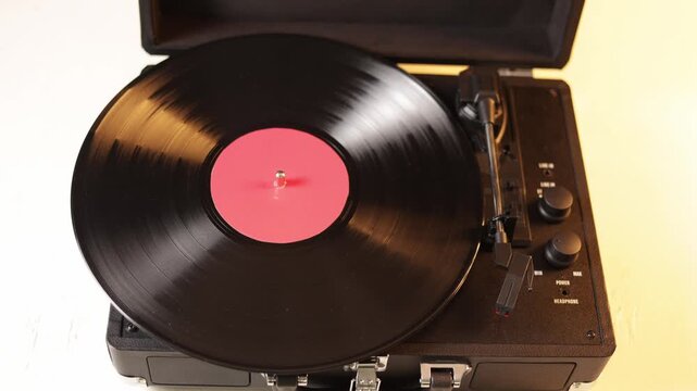 Close-up of a hand placing a vinyl record on a turntable