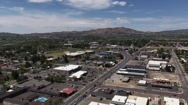 Aerial ascending over small town Vernal Utah in Uinta high desert Mountains in spring on sunny day