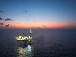 Fototapeta premium Aerial View of Offshore Jack-Up Rig and Production Platform at Sunset. Offshore Energy Exploration and Production.