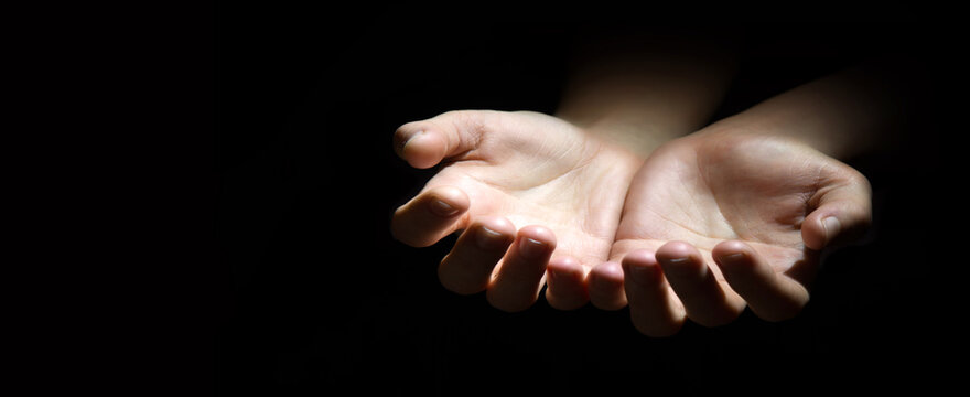 Asking hands on black backdrop