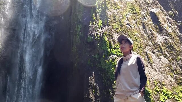 Asian woman vacation at Dolo waterfall. One of beautiful waterfall in East Java, Indonesia.