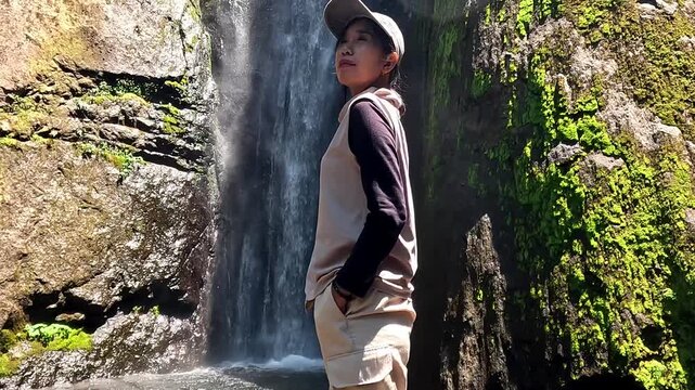 Asian woman vacation at Dolo waterfall. One of beautiful waterfall in East Java, Indonesia.