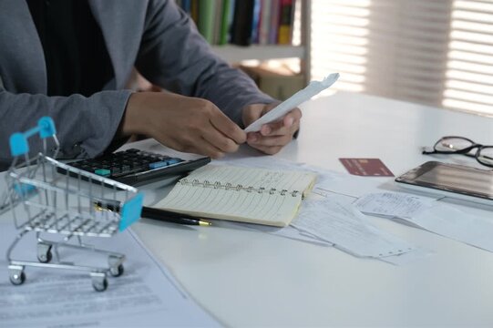 An accountant reviews receipts. Accounting concepts and financial literacy. A person reviews a stack of checks and paper receipts. Excessive, irrational, and reckless spending. Financial problems. Fin