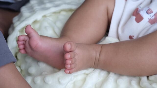 baby legs close up, baby lies in baby seat with tiny feet raised in the air, child time, highlighting early sensory and motor development, home life, childhood growth
