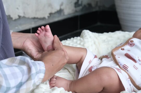 Massaging the soles of the baby's feet. Close-up of a professional infant foot massage focusing on the baby's heel. This therapeutic technique promotes relaxation and potential health benefits for inf